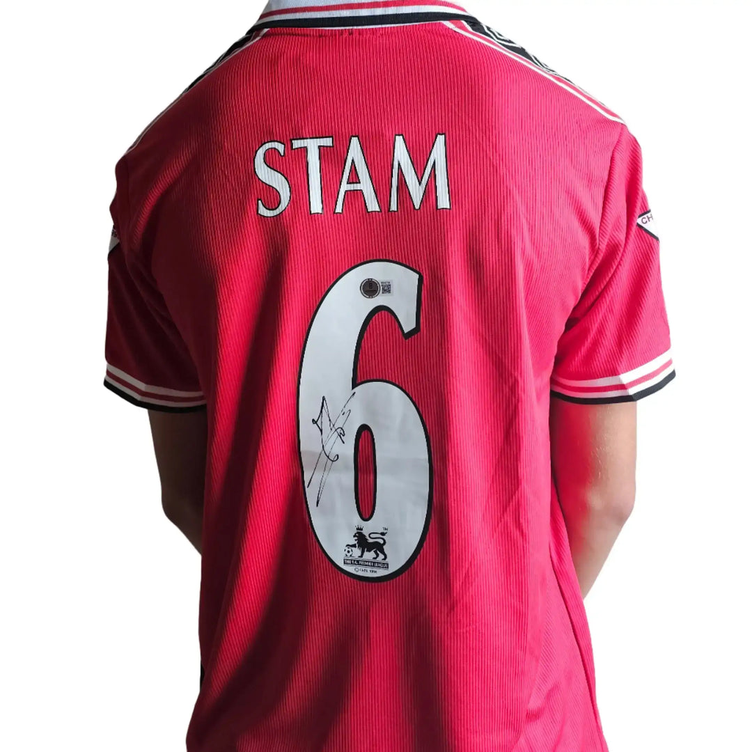 Back view showing No. 6, Stam name, and signature detail on red football shirt.