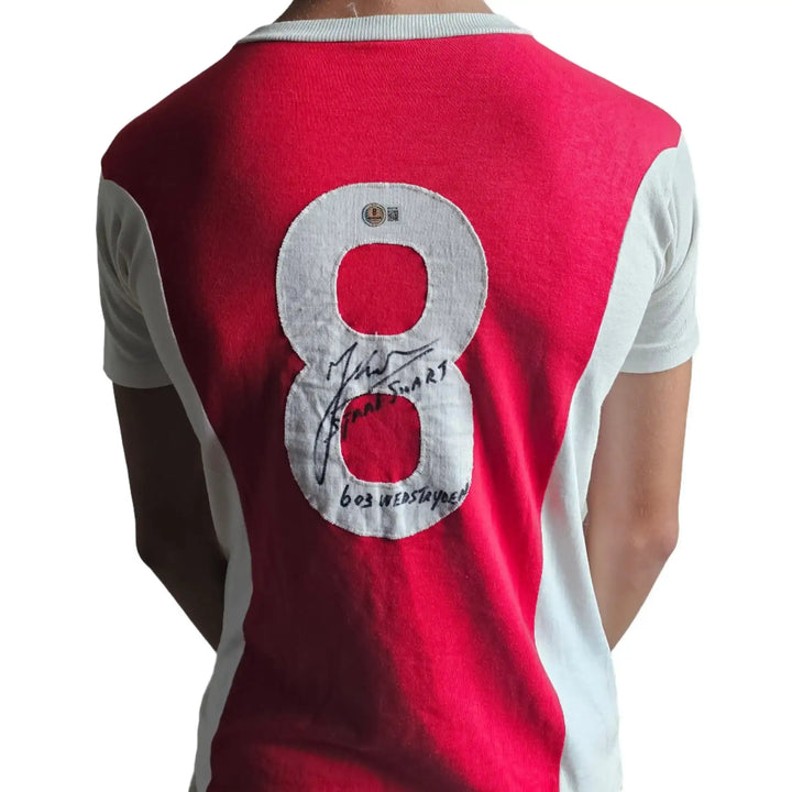 Back view showing No. 8 and signature of Sjaak Swart on red and white football shirt.