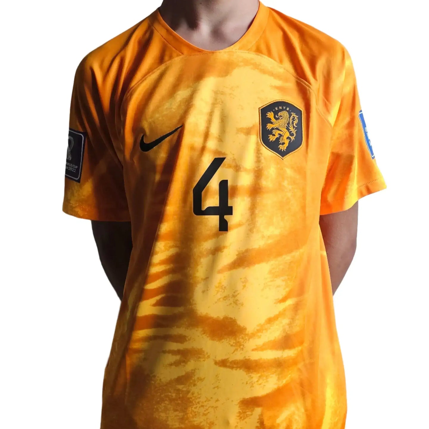 Back view showing No. 4 and crest with lion emblem on an orange football shirt.