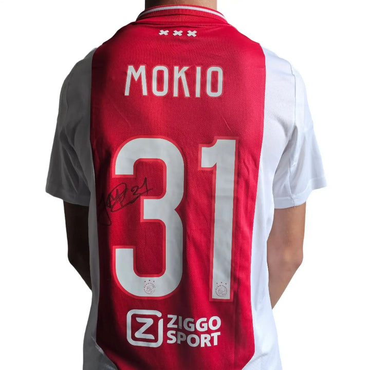 Back view showing No. 31, name Mokio, and signature on a red and white football shirt.