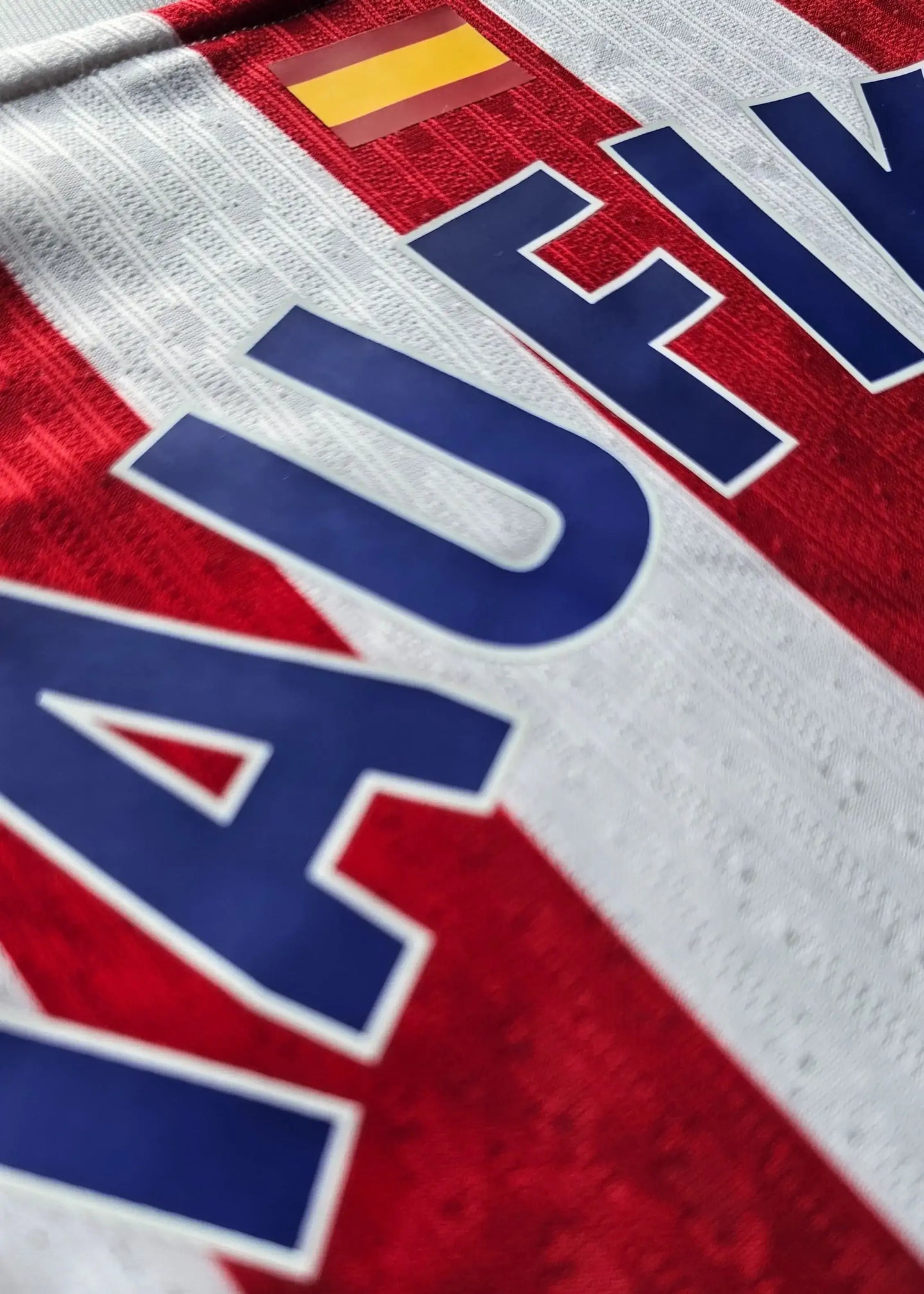 Detail of the Taufik Seidu 28 name and number on a red and white Atlético Madrid shirt.