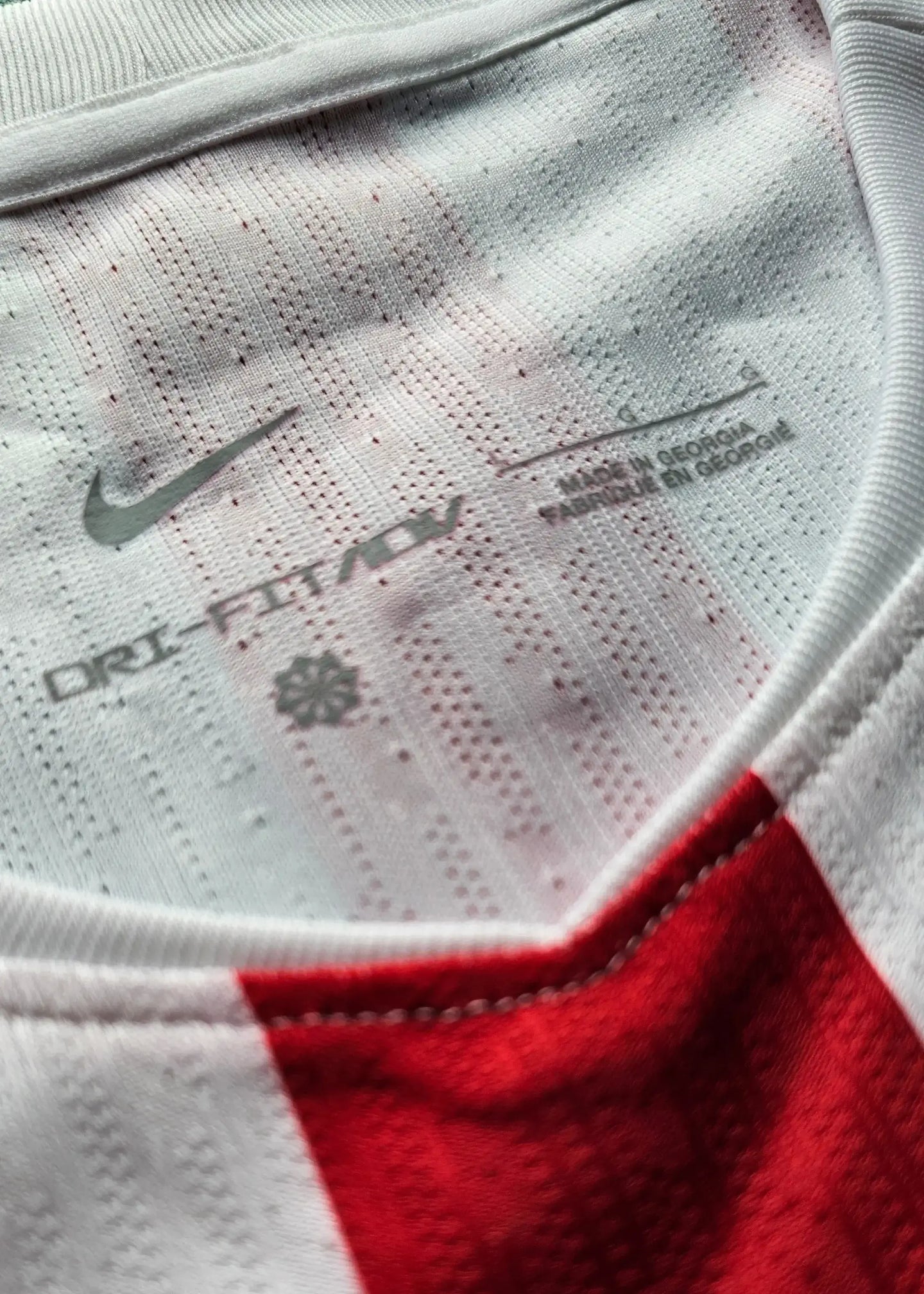 Nike DRI-FIT detail with Made in Georgia label on the interior of a red and white football shirt.