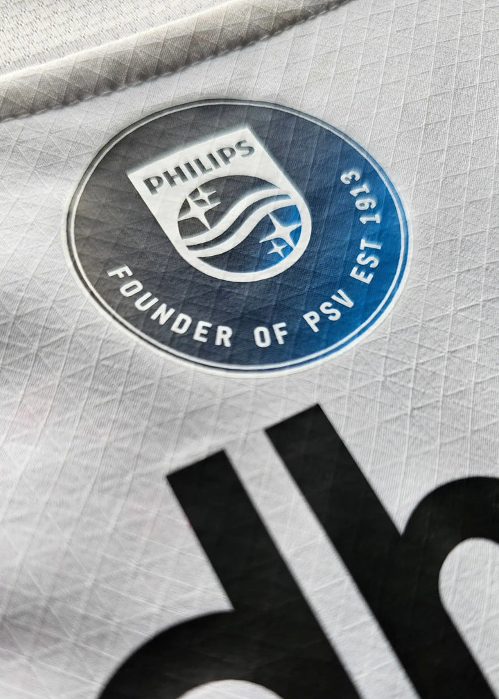 PSV Eindhoven crest featuring Philips and 'FOUNDER OF PSV EST 1913' on a white shirt.