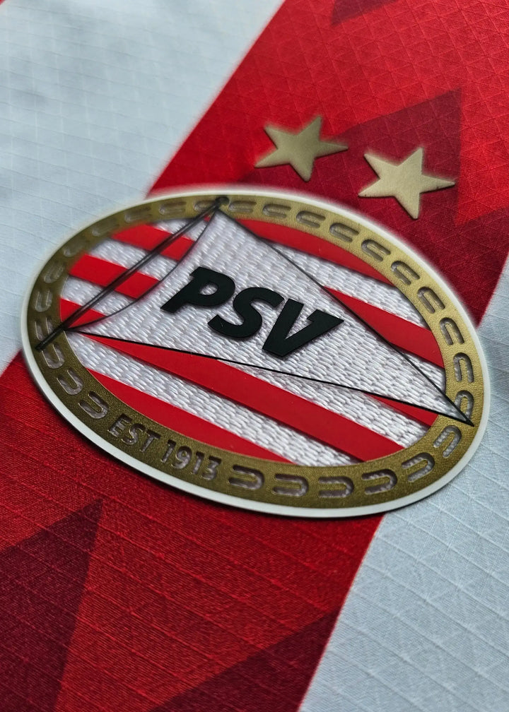 PSV Eindhoven crest with two stars above; established 1913, on a red and white shirt.