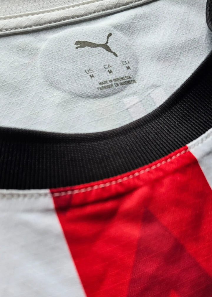 Care label on collar of PSV Eindhoven shirt showing size details and PUMA logo.