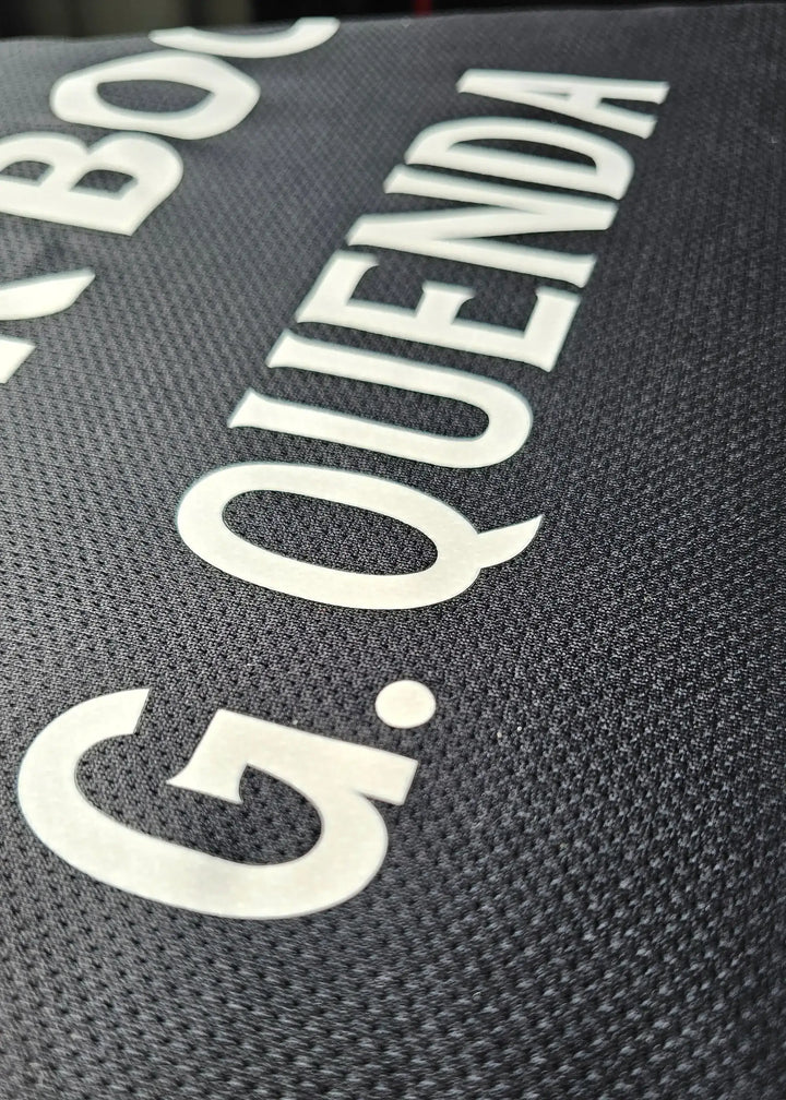 Detail of the name 'G. QUENDA' on a black Sporting CP match-worn shirt.