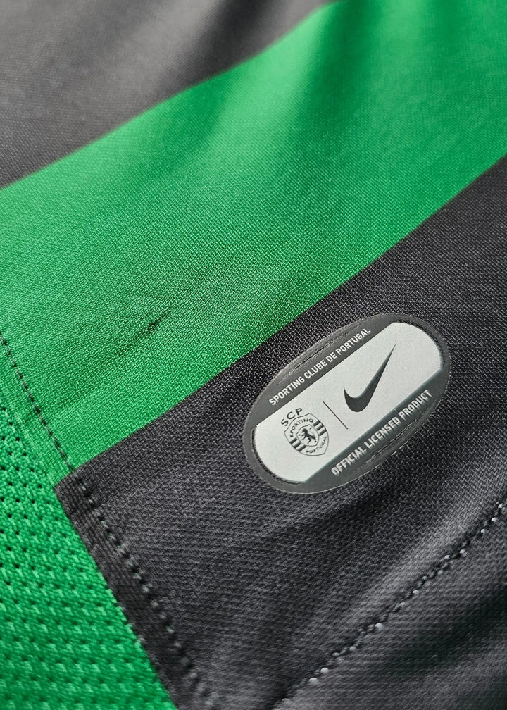 Close-up of the Nike logo and Sporting CP crest on a green and black striped match-worn shirt.