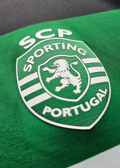 Sporting CP crest detail featuring the lion and white lettering against a green background.