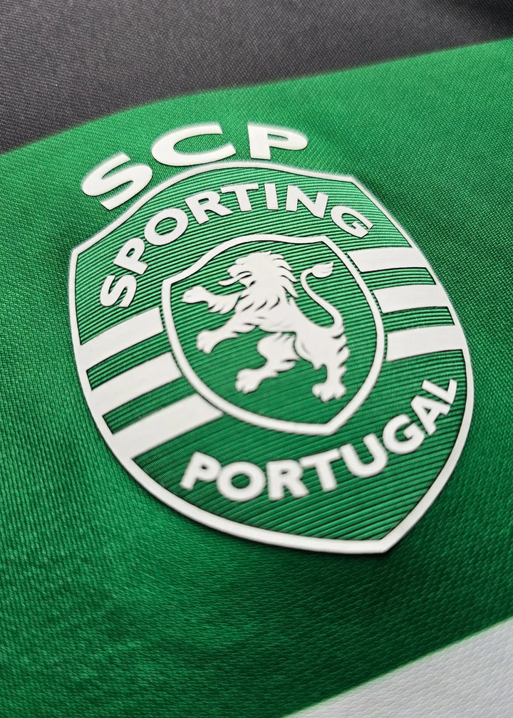 Sporting CP crest detail featuring the lion and white lettering against a green background.