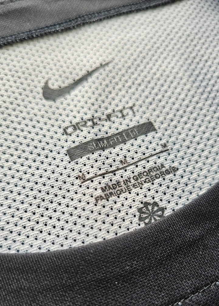 Nike tag detailing with 'DRI-FIT' and care instructions visible on the shirt's inner neck.