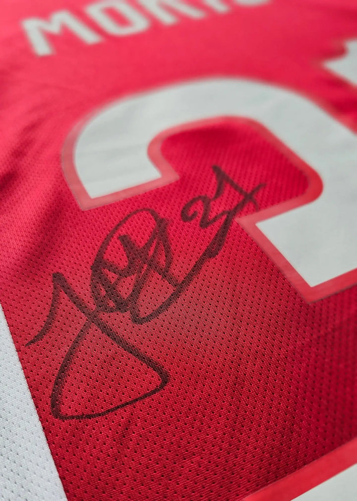 Close-up of Jorthy Mokio's No. 31 with a black signature on a red football shirt.