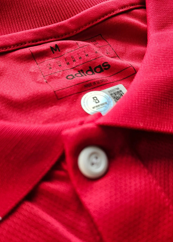 Red shirt collar showing adidas label with size M and care label.