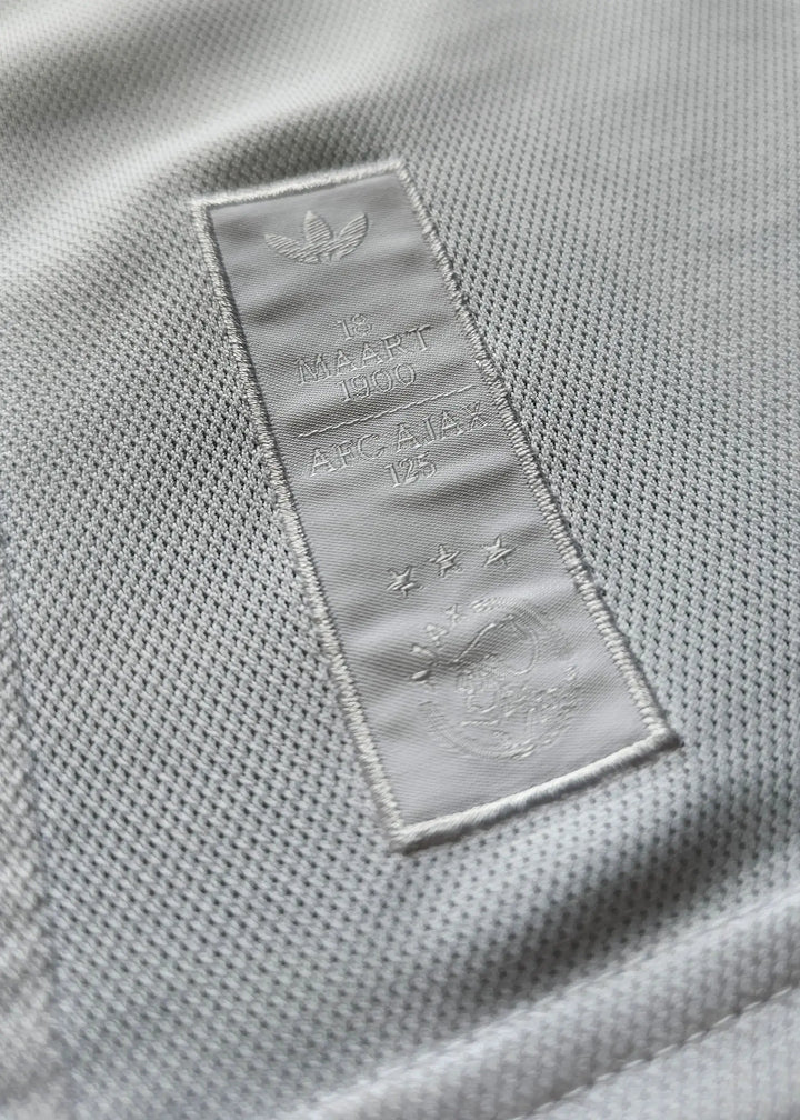Crest detail featuring AFC Ajax 125th Anniversary text and three stars on the label.