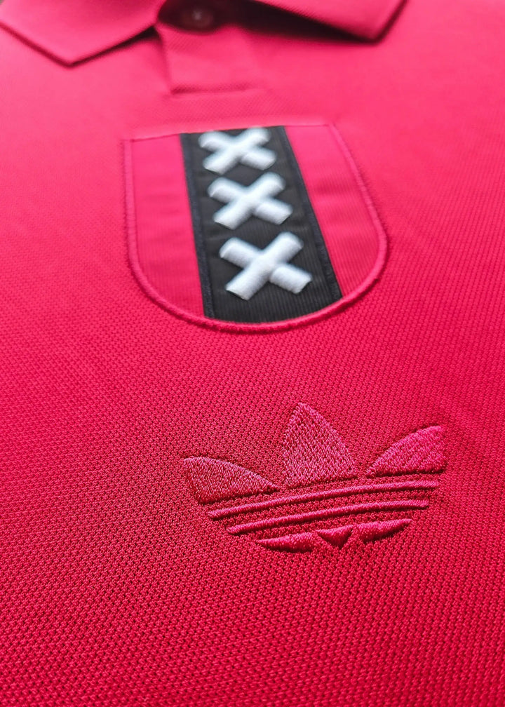 Close-up view of Ajax crest featuring three X's on a red background and adidas logo.