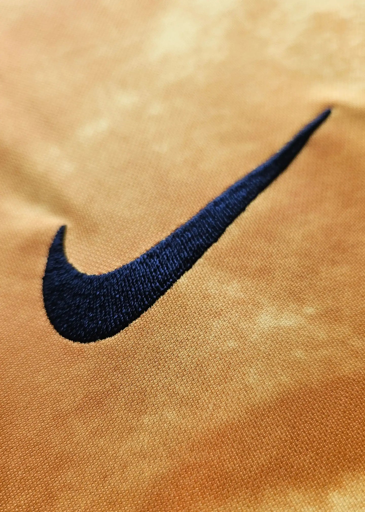 Close-up of the embroidered navy Nike swoosh on the Holland football shirt.