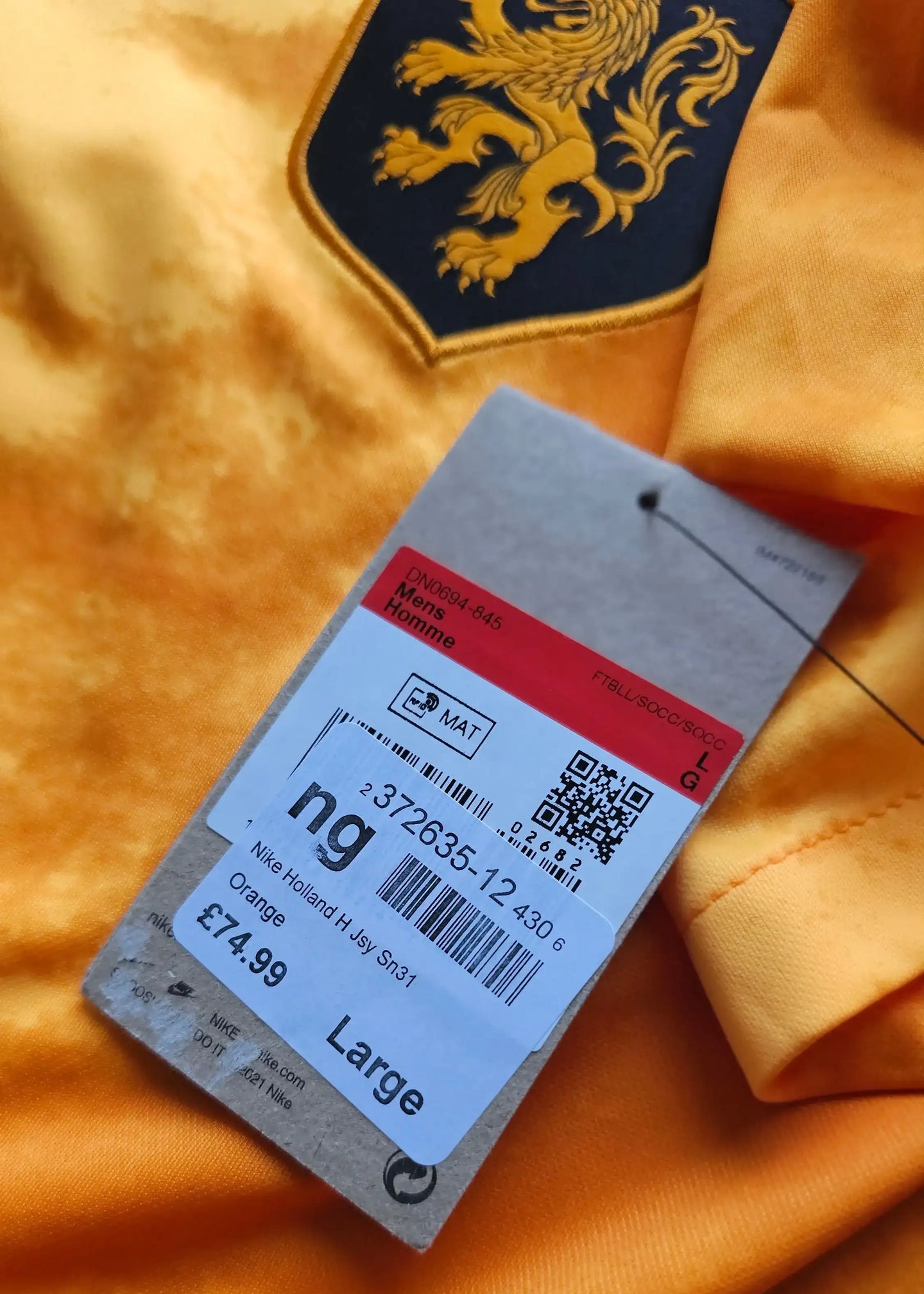 Detail showing the Holland crest in yellow and black with product tag labelled Large.