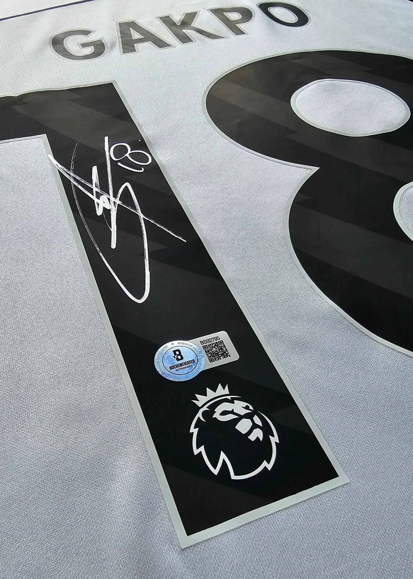 Close-up of signature and player name GAKPO on No. 18 with Premier League badge and authentication sticker.