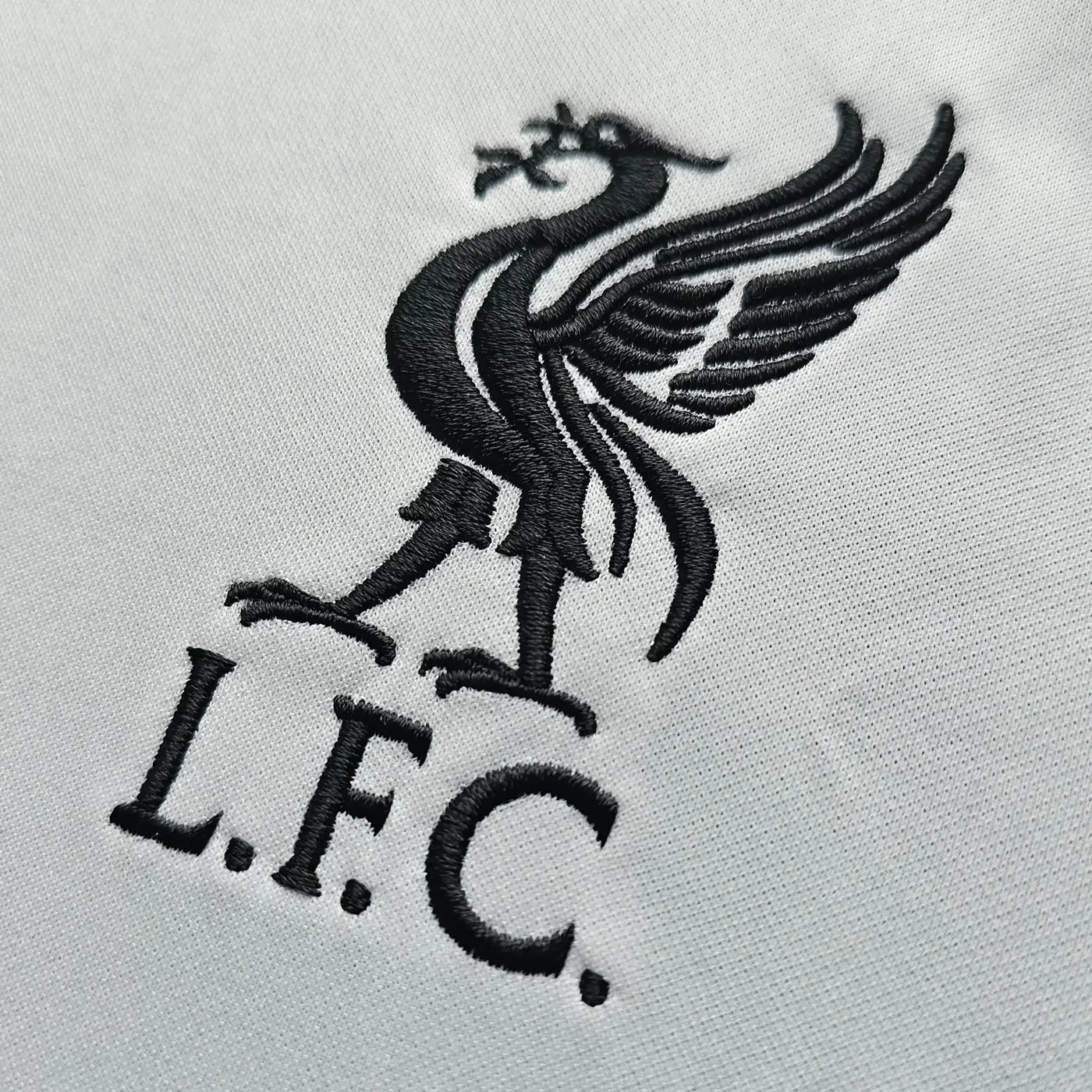 Black embroidered Liverpool FC logo on a light gray background