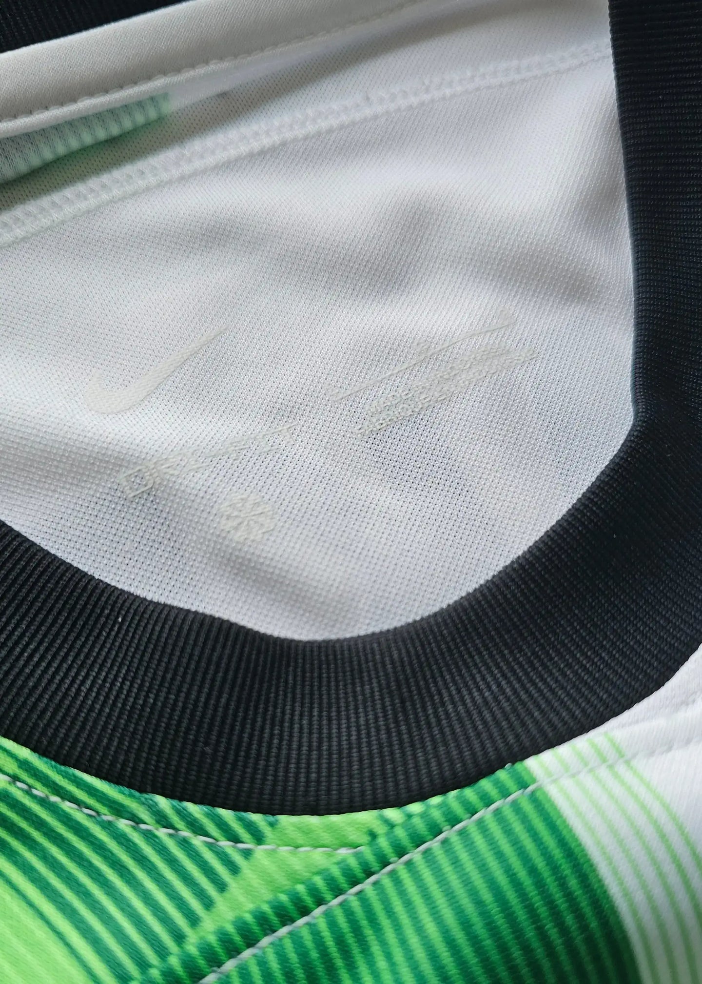 Collar detail showing Nike branding on a Cody Gakpo signed football shirt.