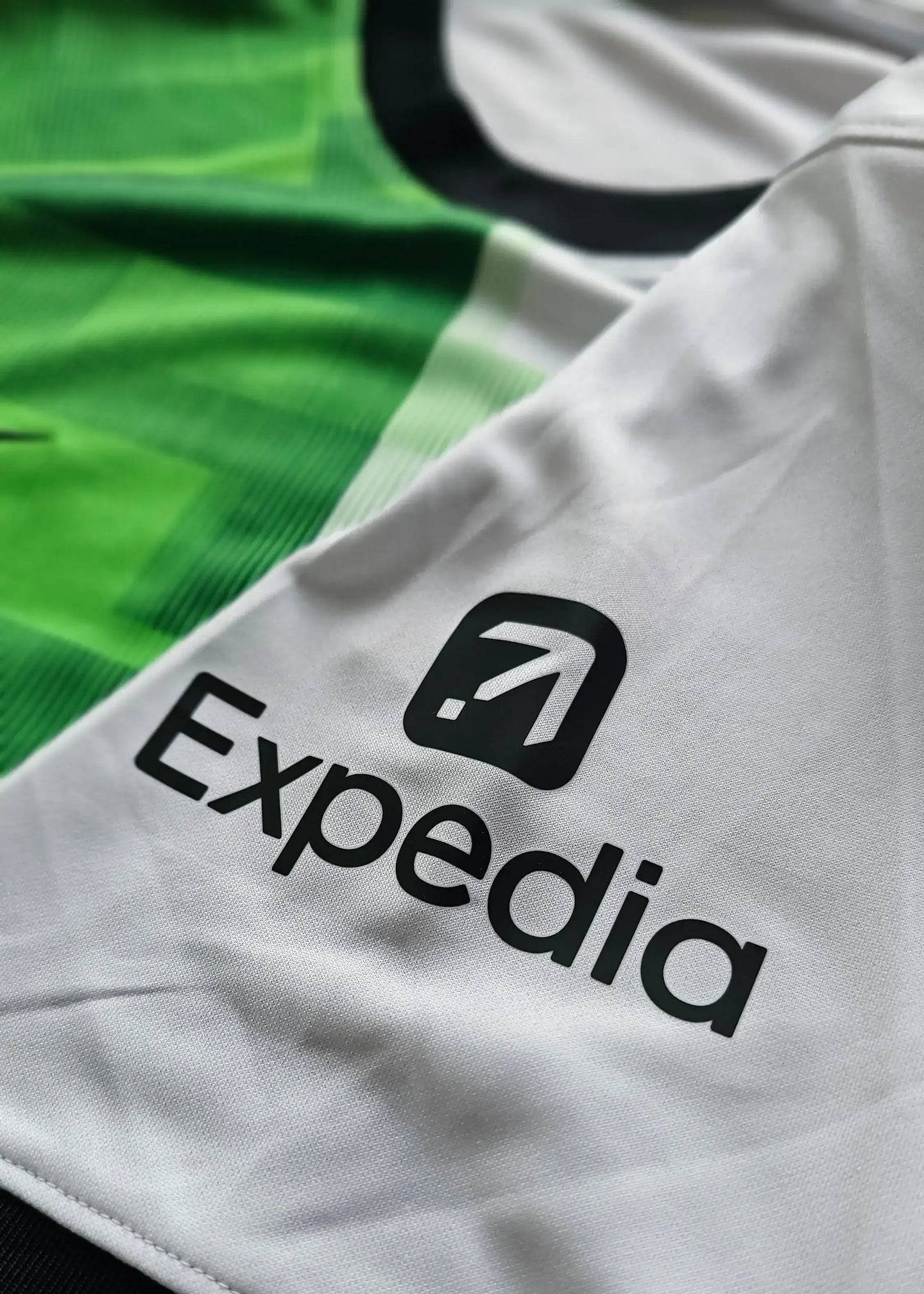 Detail view showing 'Expedia' sponsor logo on white section of football shirt.