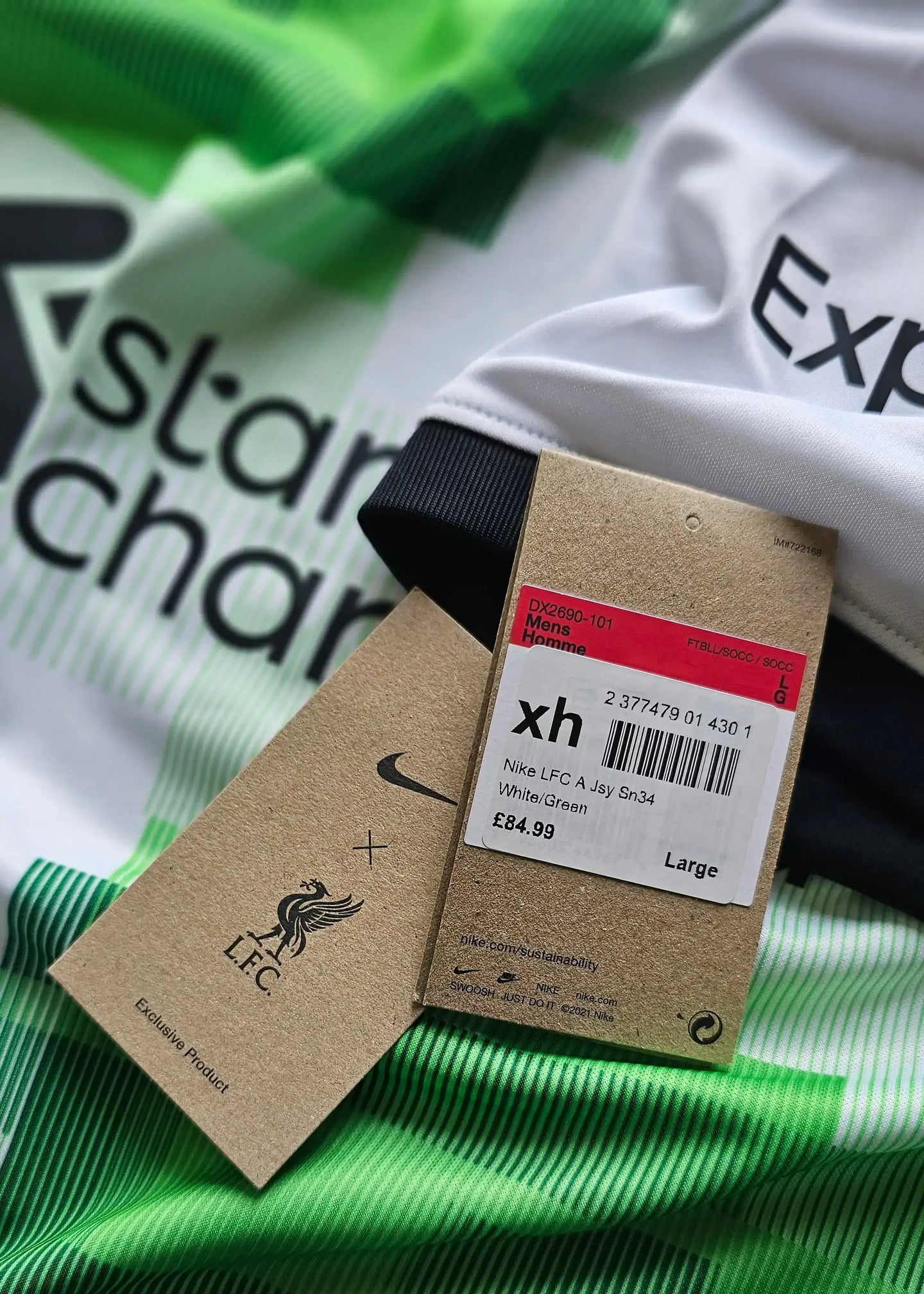 Detail view with Nike logo and LFC crest at the neckline, with tags showing size Large and price £84.99.