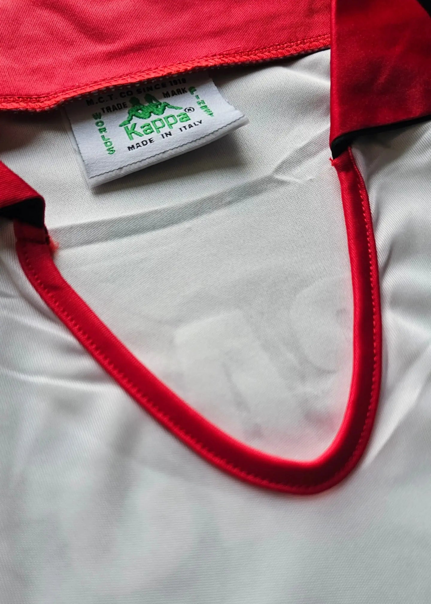 Inside view showing red collar trim and Kappa tag labeled 'MADE IN ITALY.'