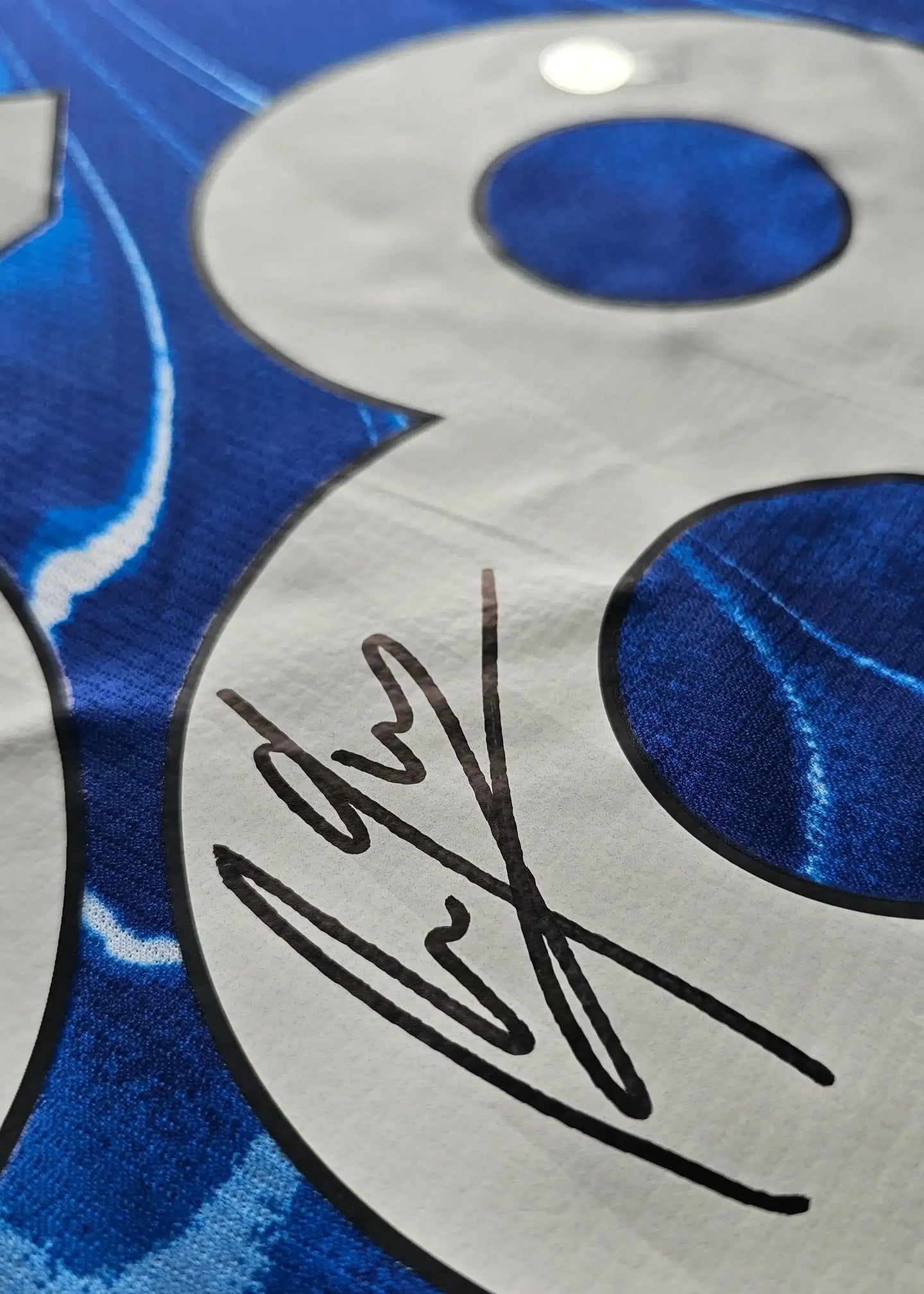 Close-up view of No. 38 with signature on blue fabric.
