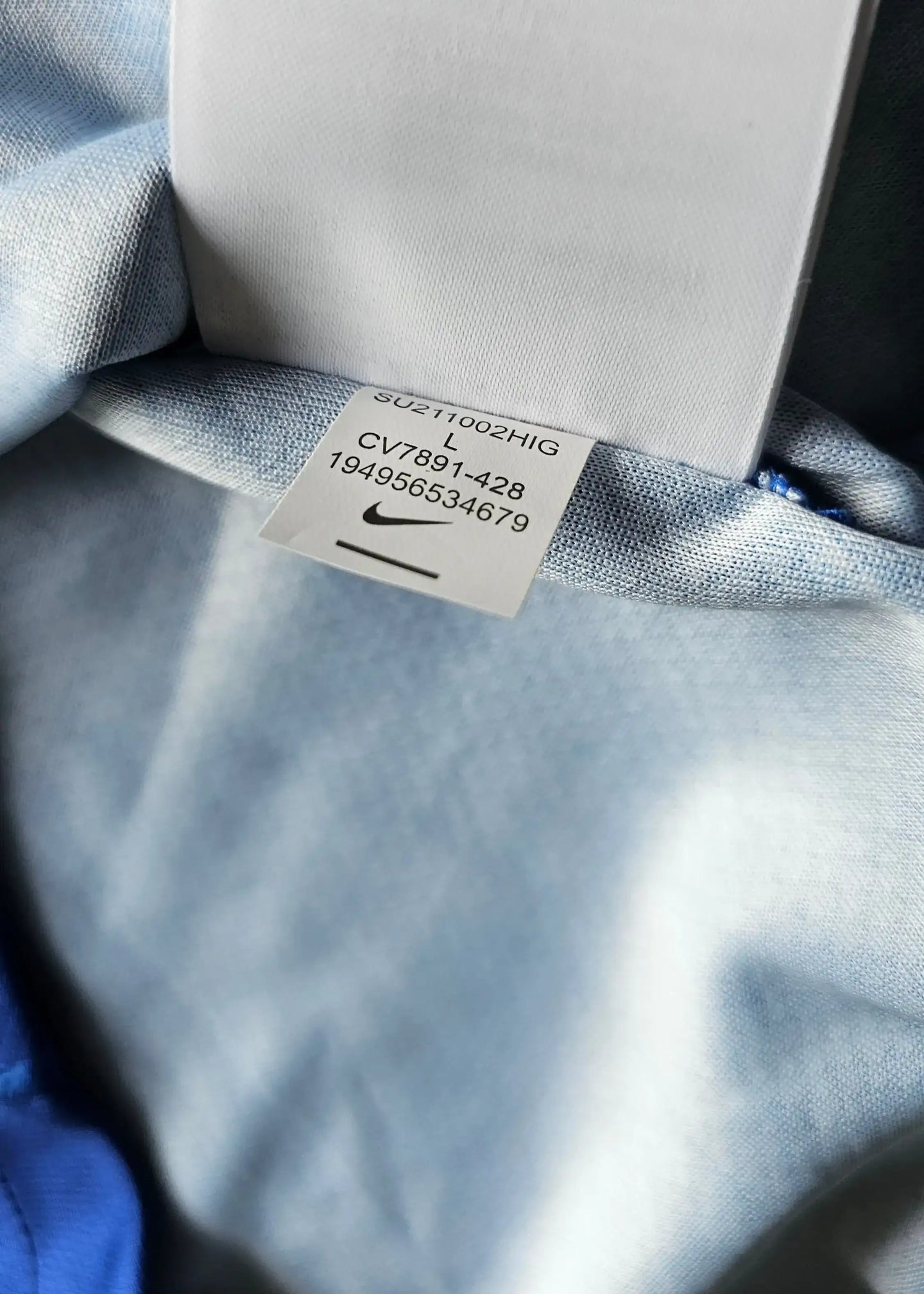 Tag showing size L and Nike details on the inside of a signed football shirt.