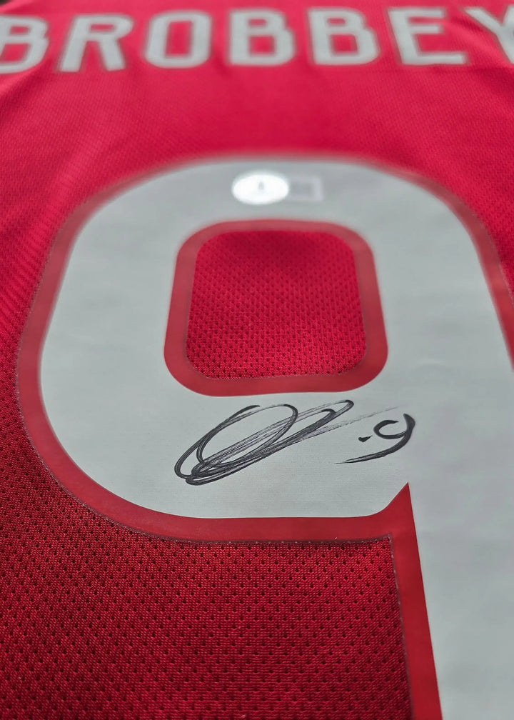 Detail showing No. 9 with Brobbey's signature on a red football shirt.