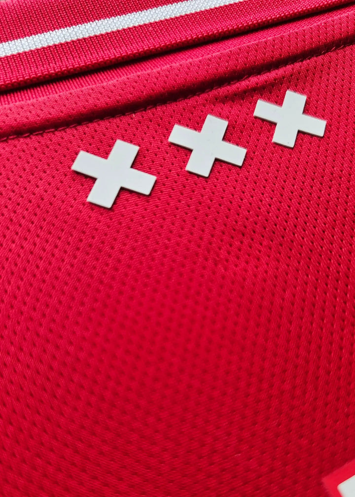 Detail view showing three white crosses on a red fabric background.
