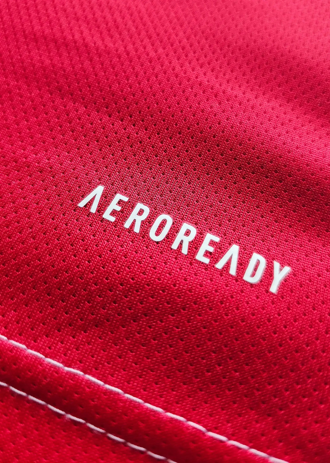Close-up showing the word 'AEROREADY' on the red fabric of the football shirt.