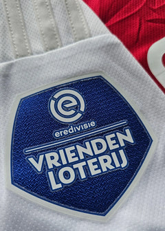 Detail view of Vrienden Loterij badge and Eredivisie text on the signed Ajax football shirt.