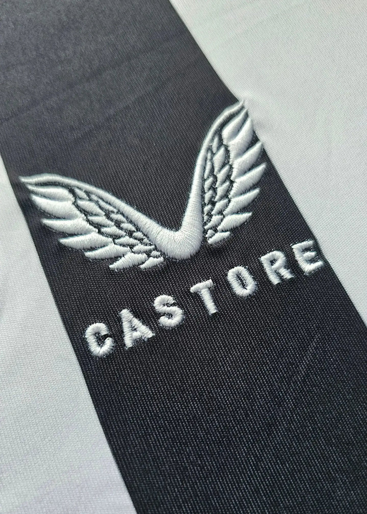 Close-up of the CASTORE logo featuring wings on a black and white striped football shirt.
