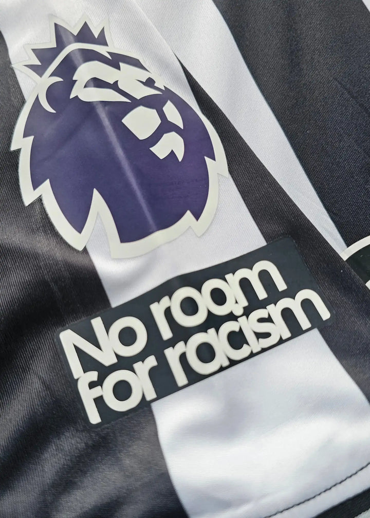 Close-up showing Newcastle crest and 'No room for racism' message on the shirt.