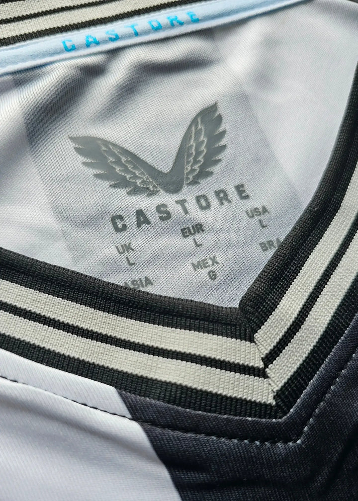 Crest detail featuring the Castore logo in gray with black and gray striped neckline.