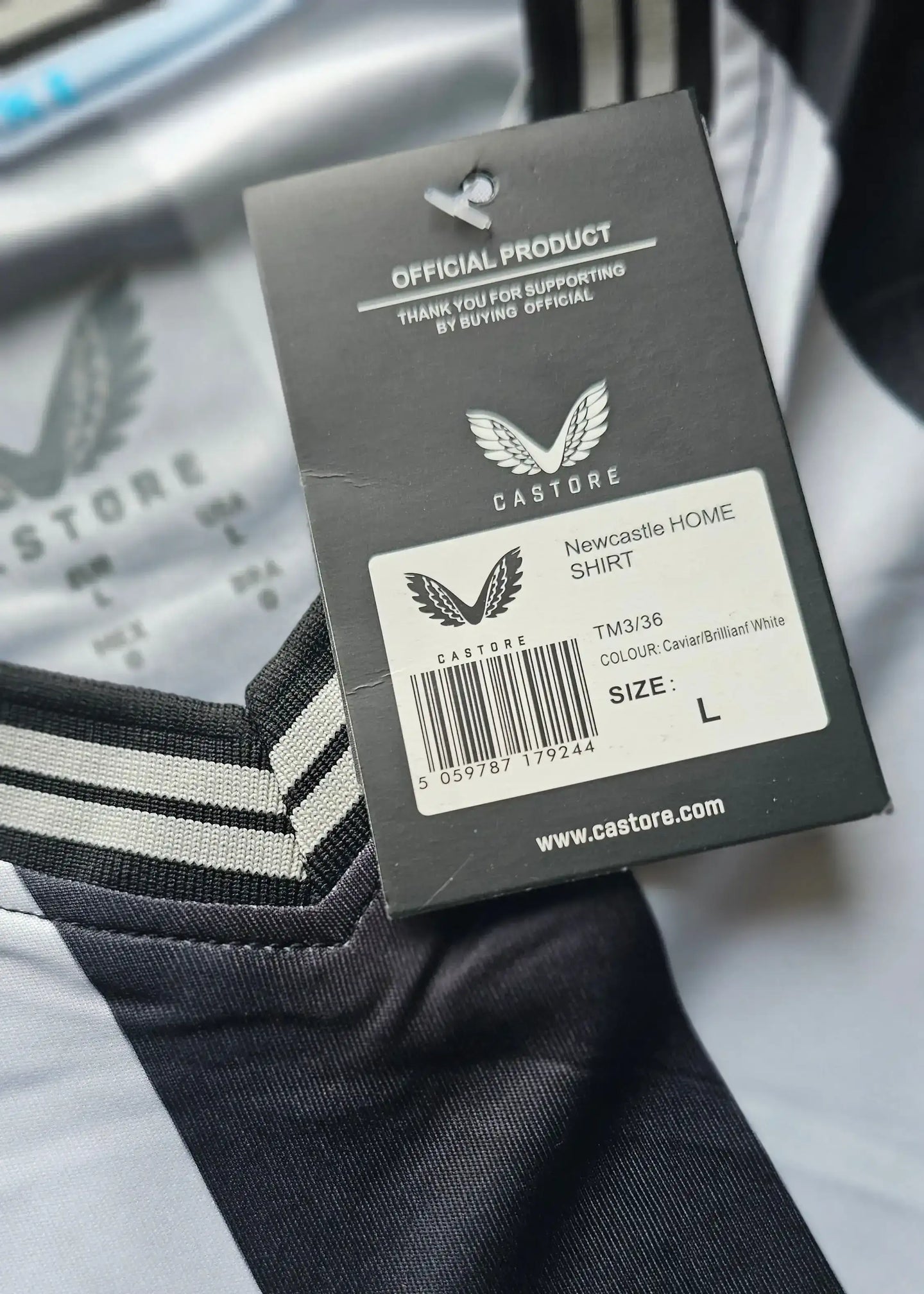 Tag detail showing 'Newcastle HOME SHIRT', size L, and Castore branding.