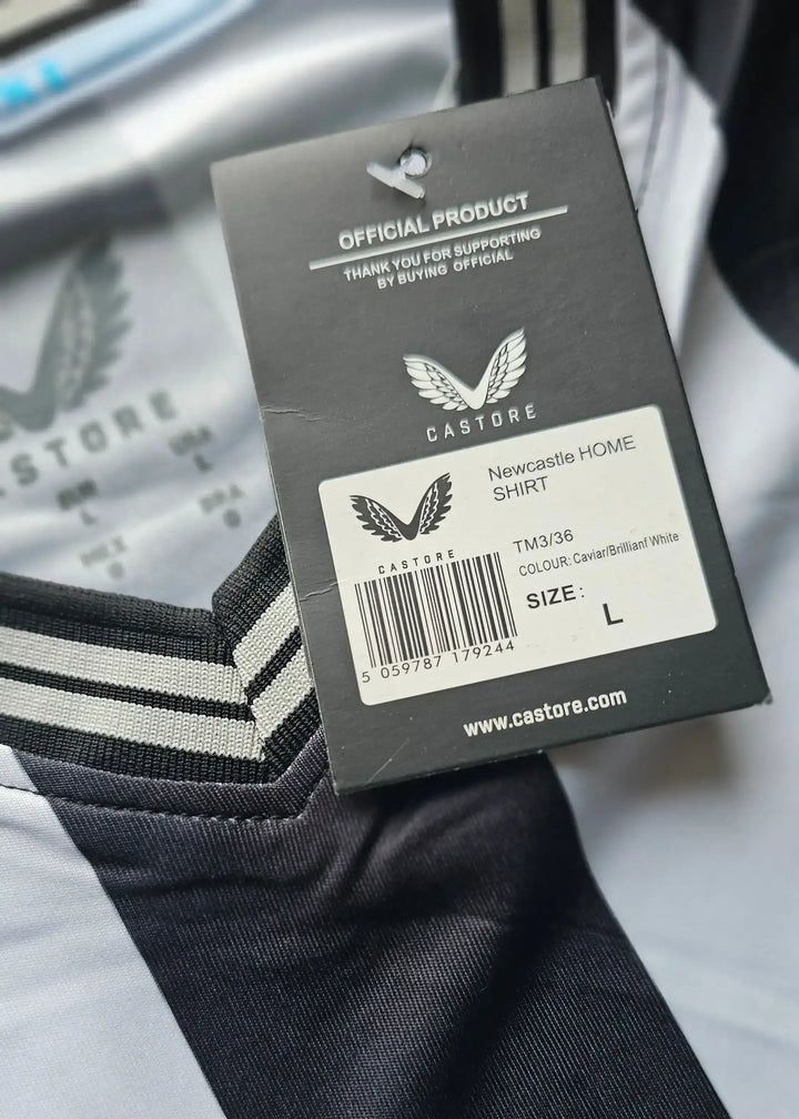 Tag detail showing 'Newcastle HOME SHIRT', size L, and Castore branding.
