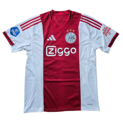 Red and white Ajax football shirt featuring 'Ziggo' sponsor, three stars, and adidas branding.