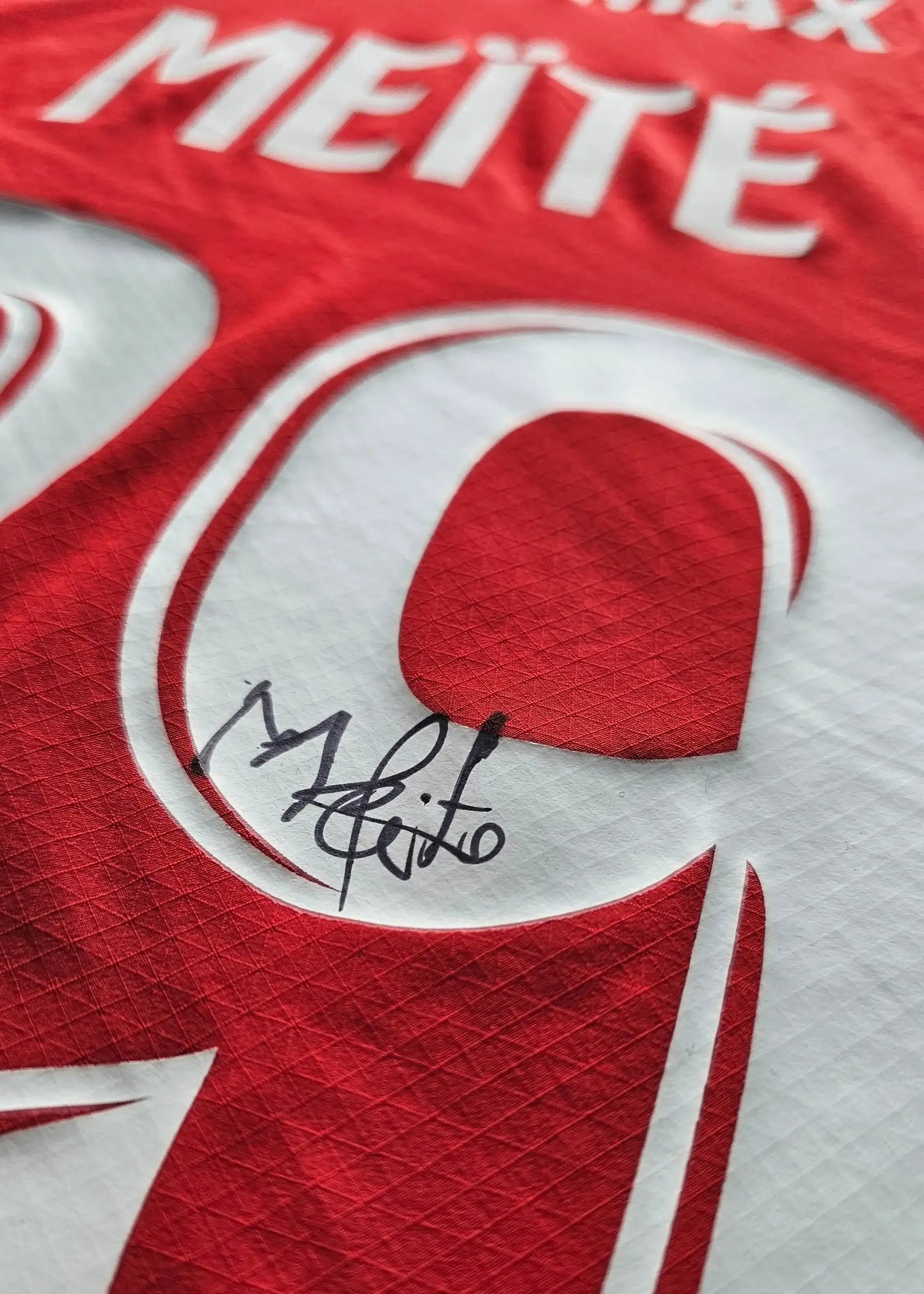 Signed Mahomed Meïté No. 39 detail on a red Stade Rennes football shirt.