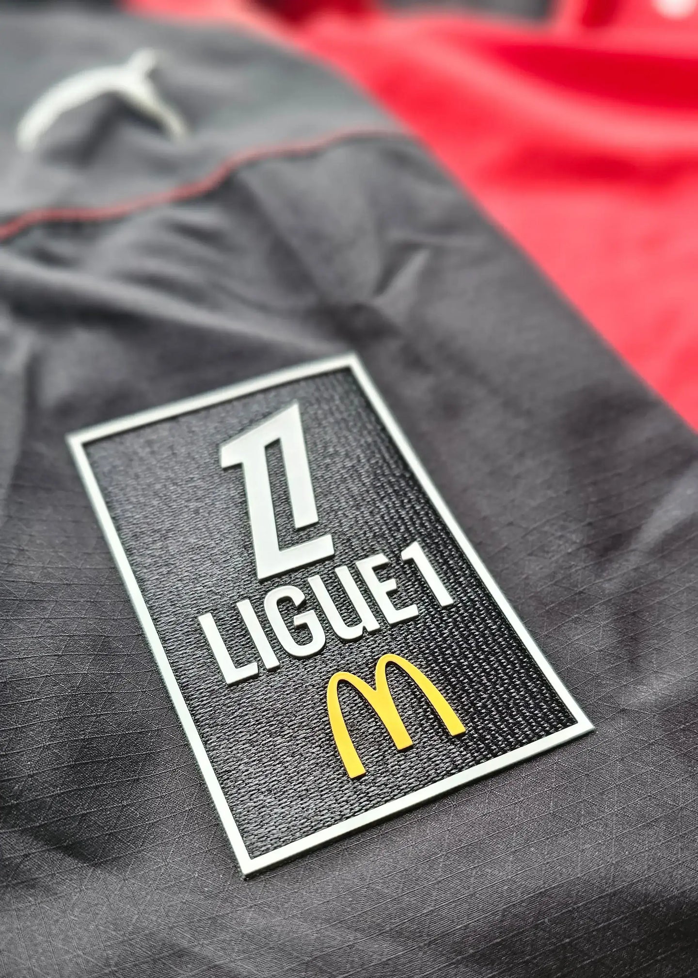 LIGUE 1 patch with McDonald's logo on a Stade Rennes football shirt in black and red.