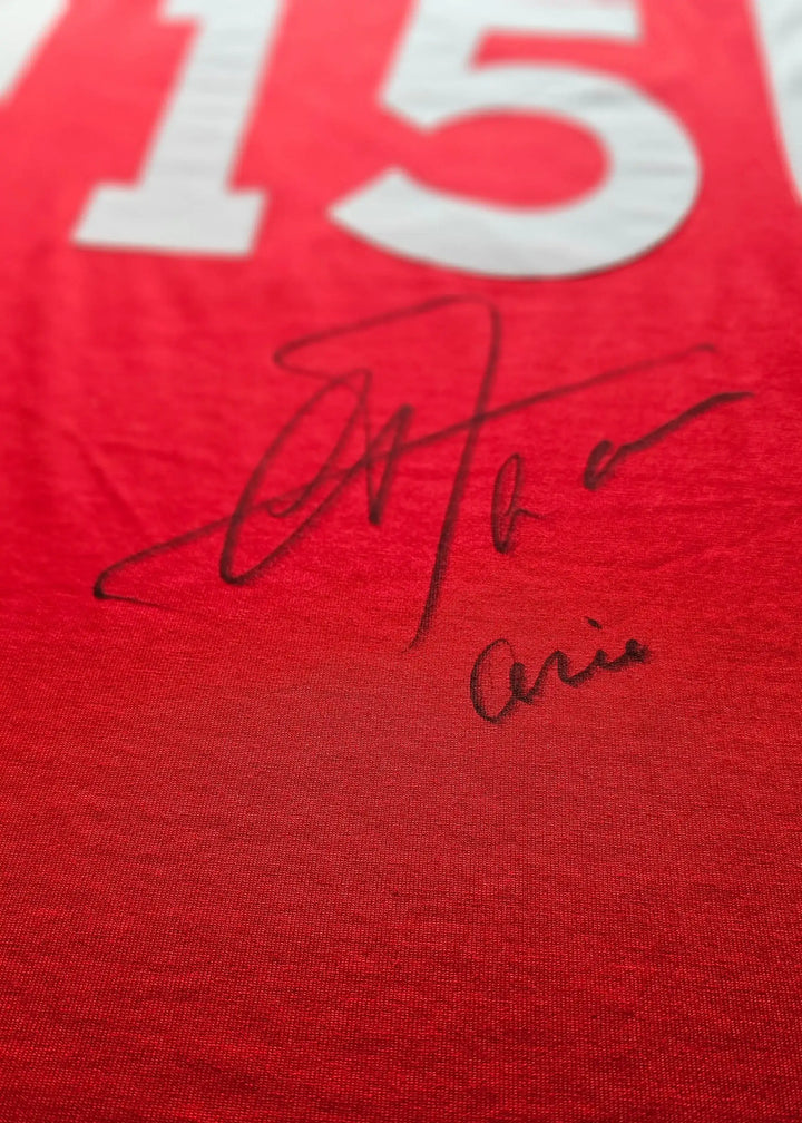 Red jersey with white No. 15 and signature of Arie Haan in black ink.