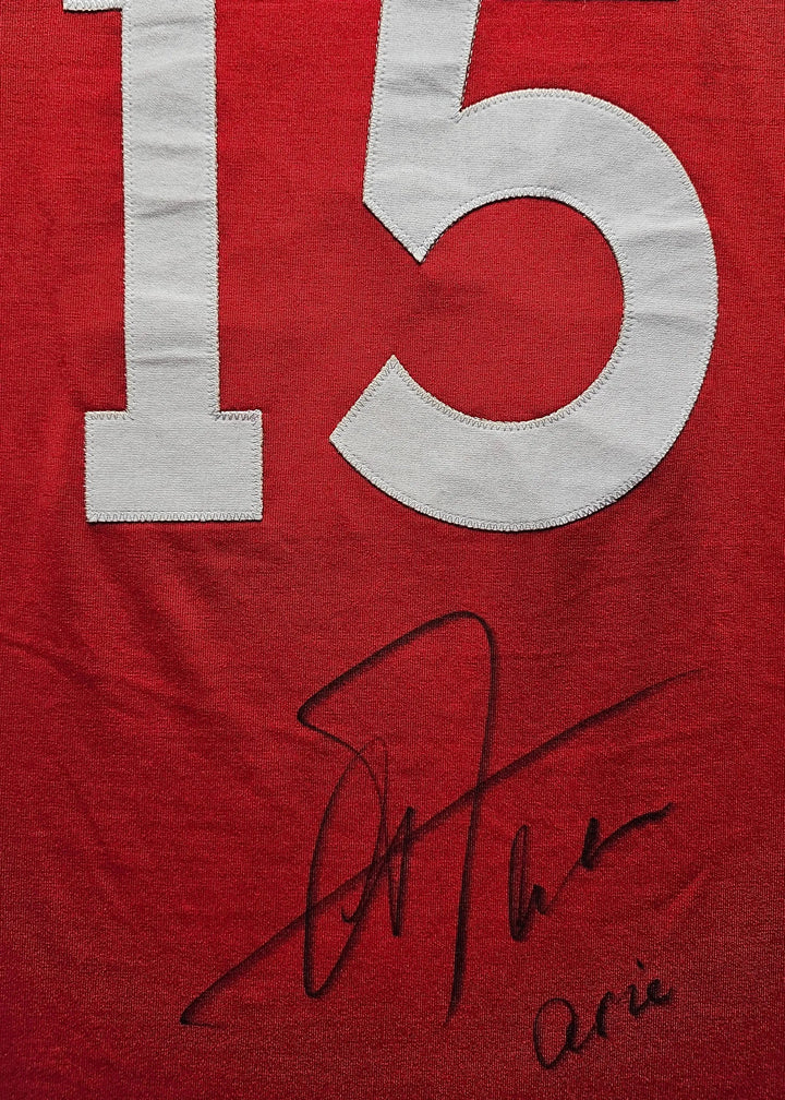 No. 25 in white on a red shirt, featuring the signature of Arie Haan.
