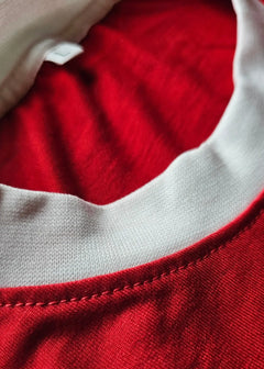 Close-up detail of the red and white collar of the Arie Haan signed Ajax football shirt.