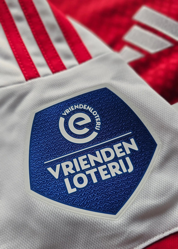 Close-up of the white patch featuring the blue VRIENDEN LOTERIJ logo with an &