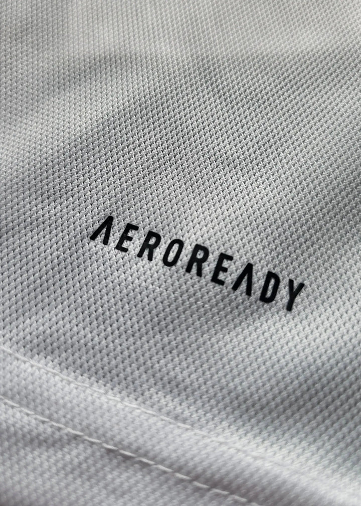 Close-up showing the 'AEROREADY' wordmark on the white fabric of the football shirt.