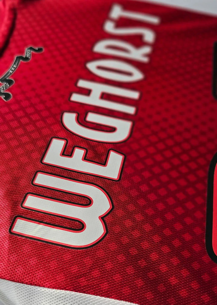 Ajax shirt with player name Weghorst and squad number 25 on a red background.