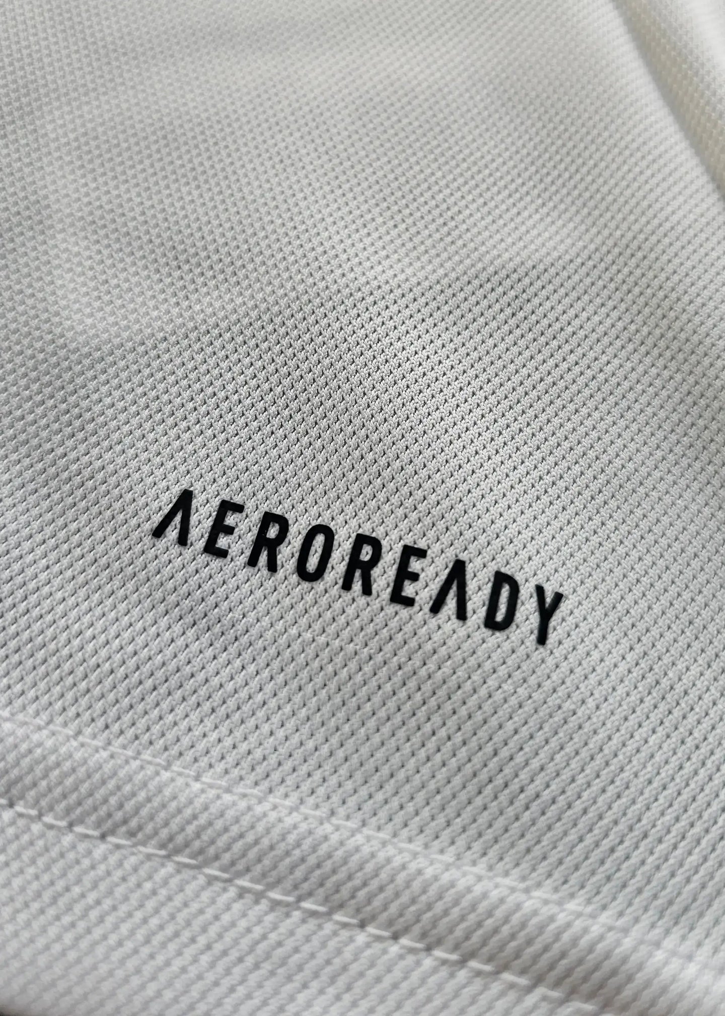 Close-up of fabric texture with 'AEROREADY' printed in black.
