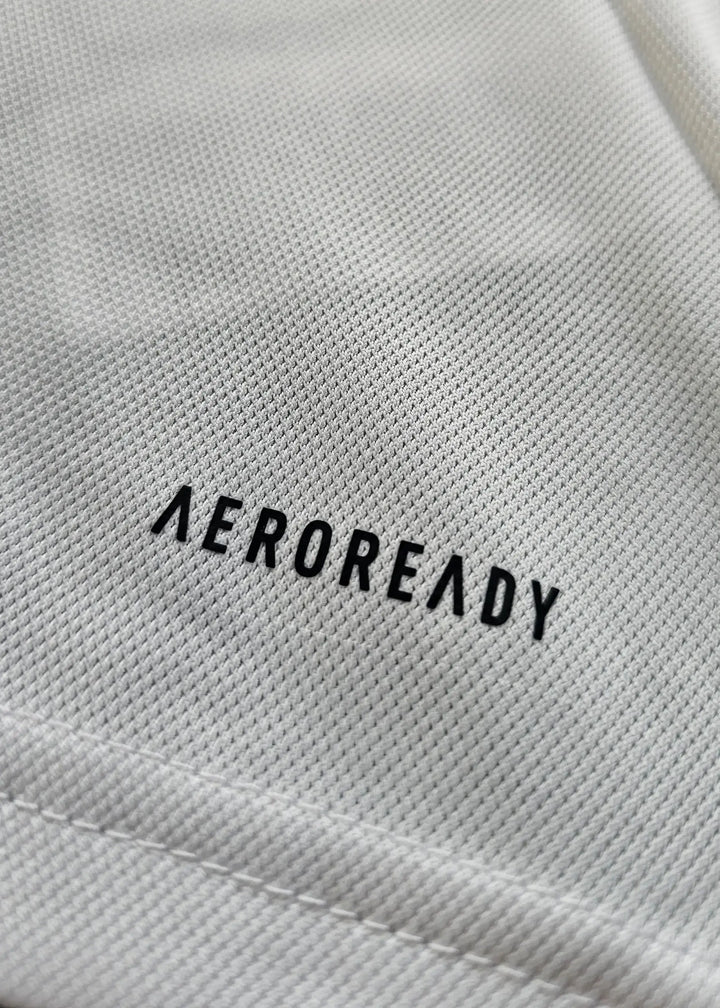 Close-up showing white fabric texture with 'AEROREADY' printed in black.