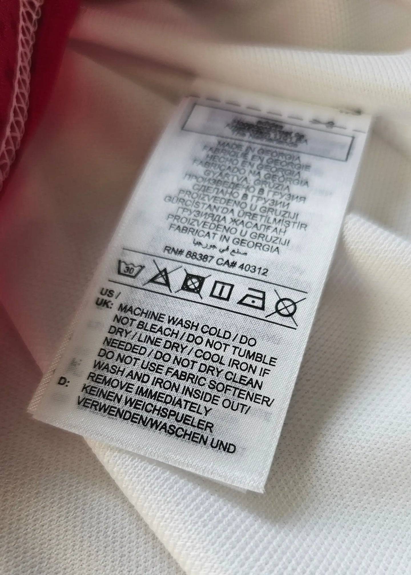 Care label with washing instructions, visible text in multiple languages.