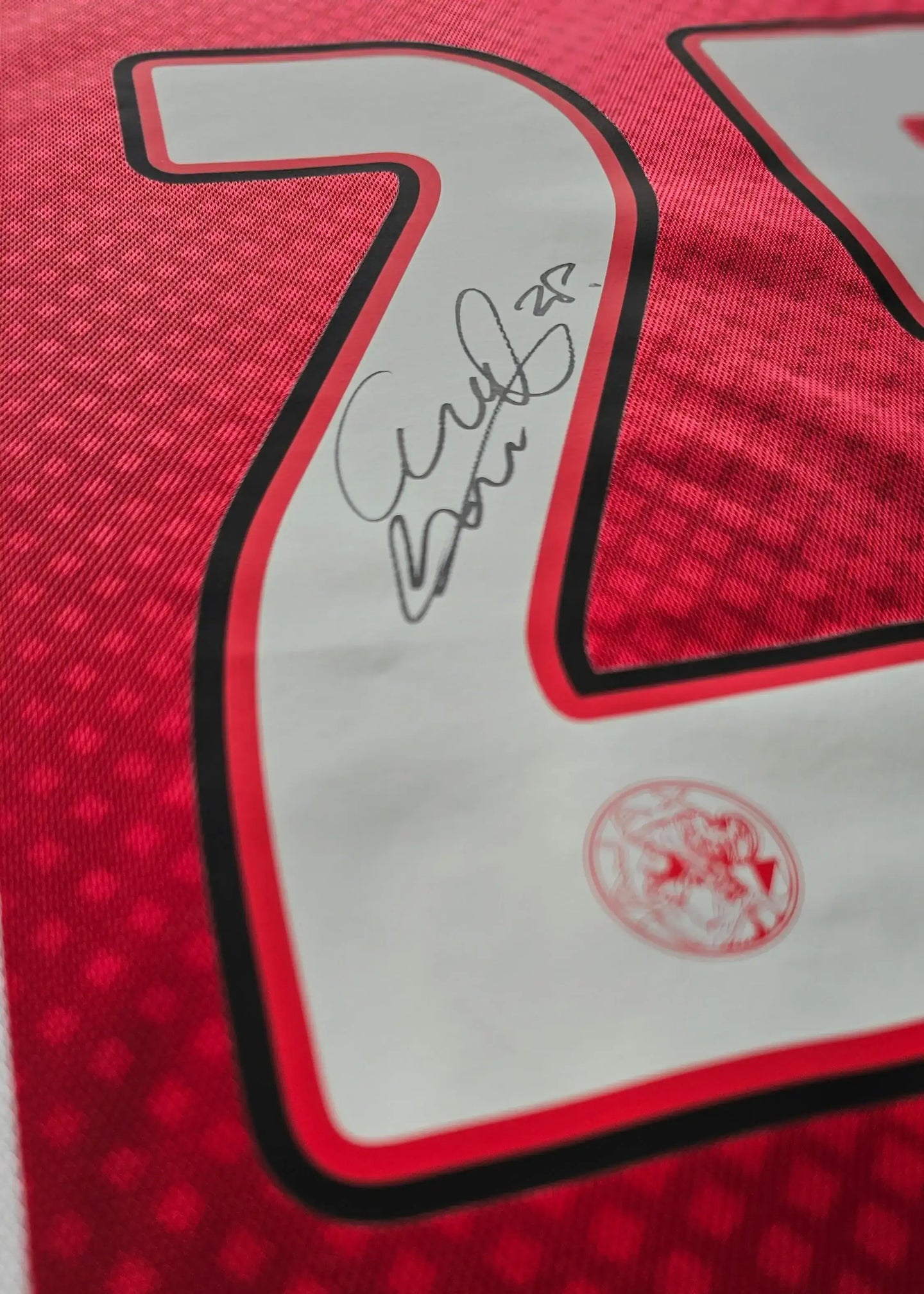 Detail of red jersey with white No. 25 and signature of Wout Weghorst.